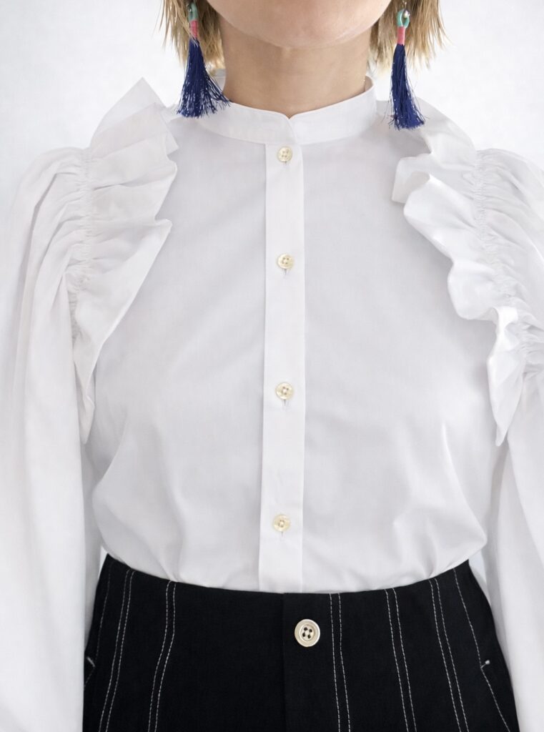 リルブラウスとステッチ入り黒パンツのコーデ